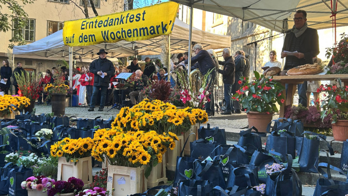 Marktstände mit vielen Blumen bei den Stuttgarter Märkten, auf einem Banner steht "Erntedankfest auf dem Wochenmarkt".