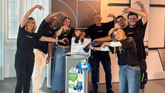 Mitarbeitende der Firma ARNO stehen um die Handy-Sammelbox Freddy Datenfresser