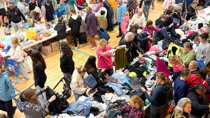 Viele Menschen laufen beim Schenktag der Gemeinde Grünkraut durch die Halle und schauen sich die angebotenen Kleidungsstücke an.