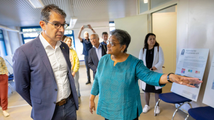 Eine Vertreterin des Welthauses führt Dr. Andre Baumann durch die Ausstellung des Welt-Hauses.